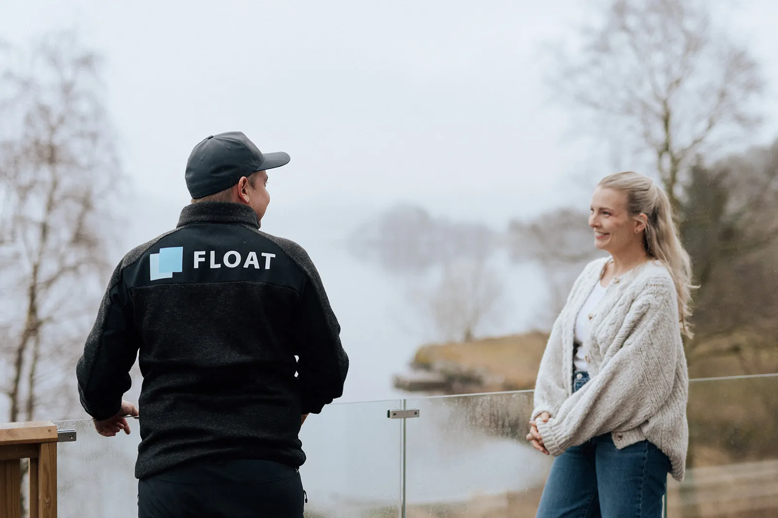 Float i samtale med kunde ved glassrekkverk